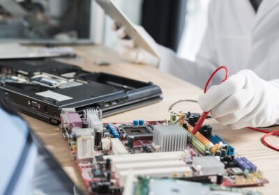 male-technician-examining-mother-board-with-digital-multimeter-1
