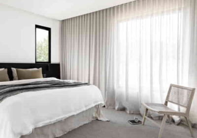 Minimalist-bedroom-with-white-bedding-black-headboard-cane-chair-and-floor-to-ceiling-linen-sheer-curtains